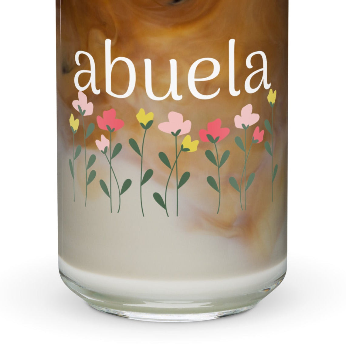 A can-shaped glass with a floral pattern and the word 'abuela' printed on it, containing a beverage.