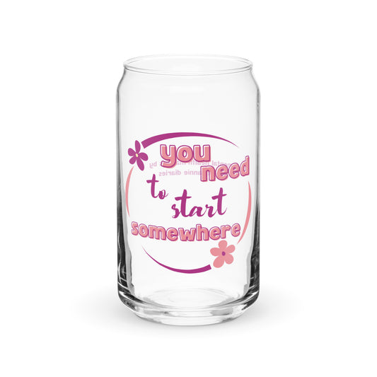 A clear glass can-shaped tumbler with pink text and floral design that reads 'You Need to Start Somewhere'.