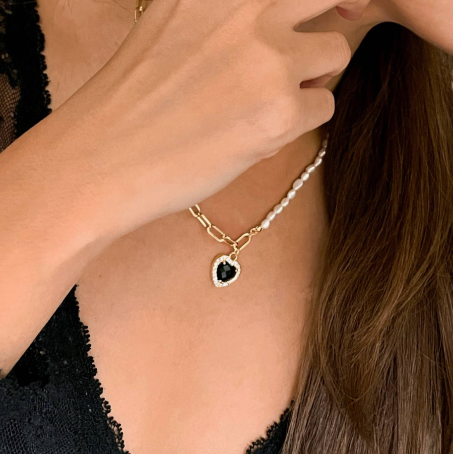 A person wearing an 18K gold plated necklace with a pearl-like bead design.