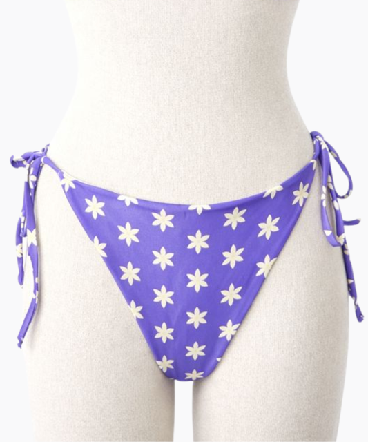 Purple bikini bottom with a light yellow floral pattern on a mannequin against a white background