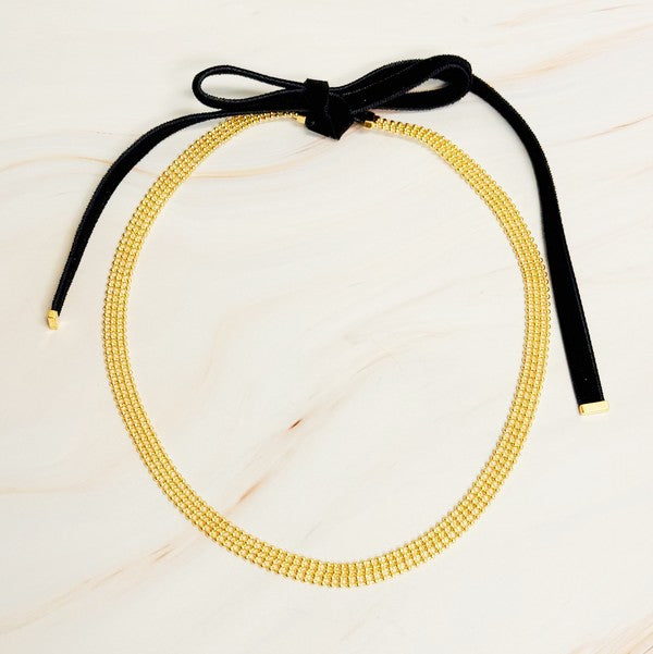 Elevate your style with the Tied in Gold Choker-Style Necklace by Ellison and Young. Featuring a delicate gold chain complemented by a chic black velvety ribbon tie, this versatile accessory adds a touch of elegance to any outfit. Perfect for day-to-night transitions, it effortlessly blends timeless sophistication with modern flair.

