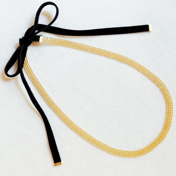 Elevate your style with the Tied in Gold Choker-Style Necklace by Ellison and Young. Featuring a delicate gold chain complemented by a chic black velvety ribbon tie, this versatile accessory adds a touch of elegance to any outfit. Perfect for day-to-night transitions, it effortlessly blends timeless sophistication with modern flair.

