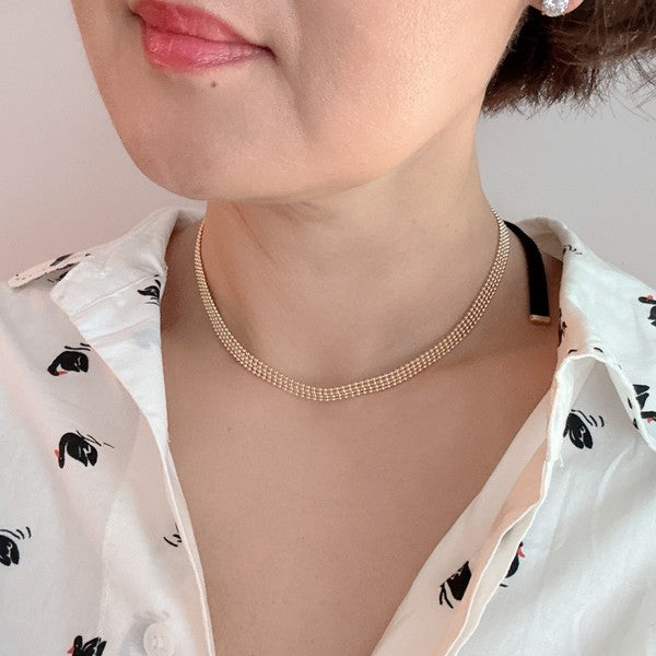 Elevate your style with the Tied in Gold Choker-Style Necklace by Ellison and Young. Featuring a delicate gold chain complemented by a chic black velvety ribbon tie, this versatile accessory adds a touch of elegance to any outfit. Perfect for day-to-night transitions, it effortlessly blends timeless sophistication with modern flair.
