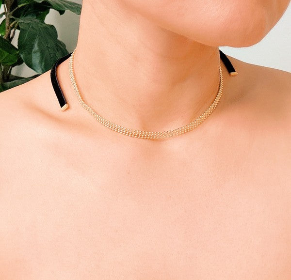 Elevate your style with the Tied in Gold Choker-Style Necklace by Ellison and Young. Featuring a delicate gold chain complemented by a chic black velvety ribbon tie, this versatile accessory adds a touch of elegance to any outfit. Perfect for day-to-night transitions, it effortlessly blends timeless sophistication with modern flair.
