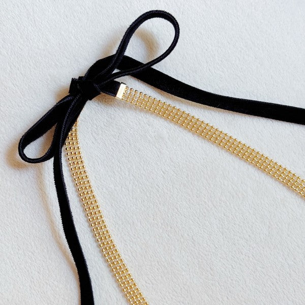 Elevate your style with the Tied in Gold Choker-Style Necklace by Ellison and Young. Featuring a delicate gold chain complemented by a chic black velvety ribbon tie, this versatile accessory adds a touch of elegance to any outfit. Perfect for day-to-night transitions, it effortlessly blends timeless sophistication with modern flair.

