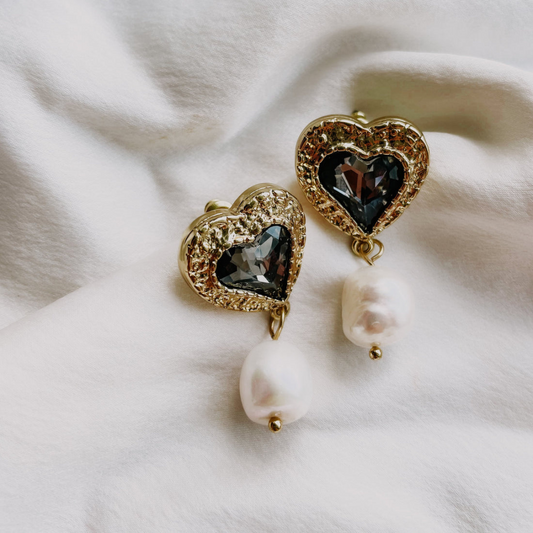 A pair of gold-plated stainless steel earrings with black onyx stones and cubic zirconia accents, featuring freshwater pearls.