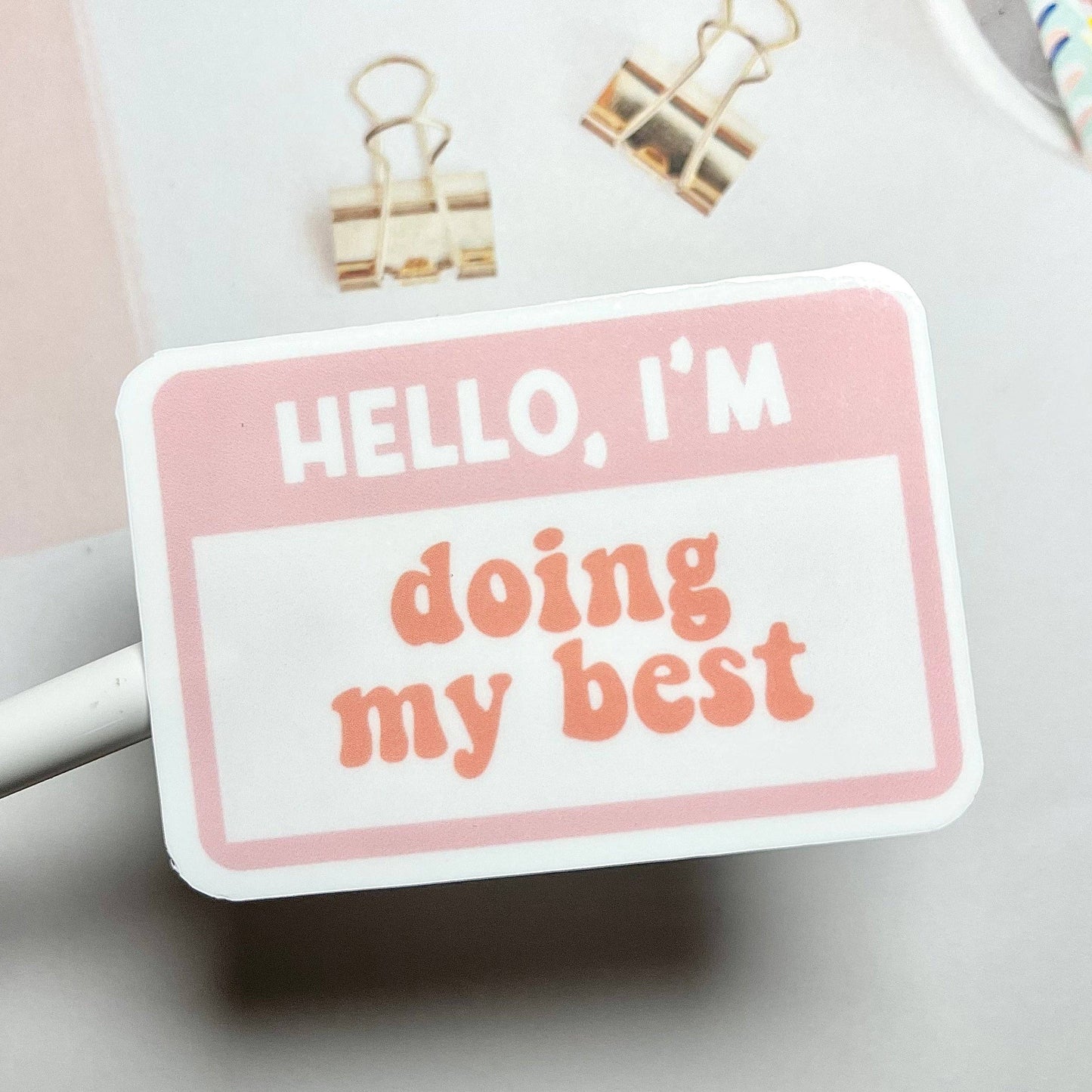 A pink sticker with the text 'Hello, I'm Doing My Best' in orange.