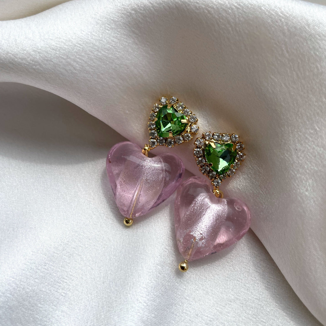 A pair of pink and green heart-shaped earrings with gold accents and greenstone inlays.